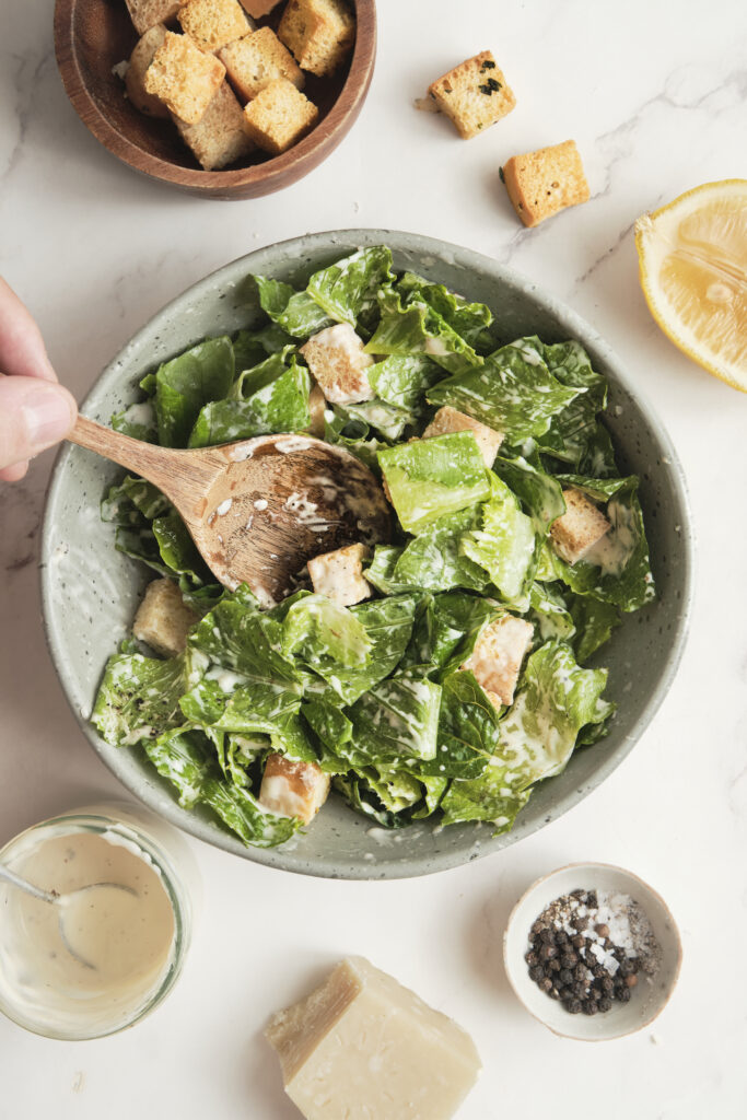 Classic Caesar salad with crisp romaine lettuce, creamy dressing, crunchy croutons, and freshly grated Parmesan cheese, served in a light, airy setting.