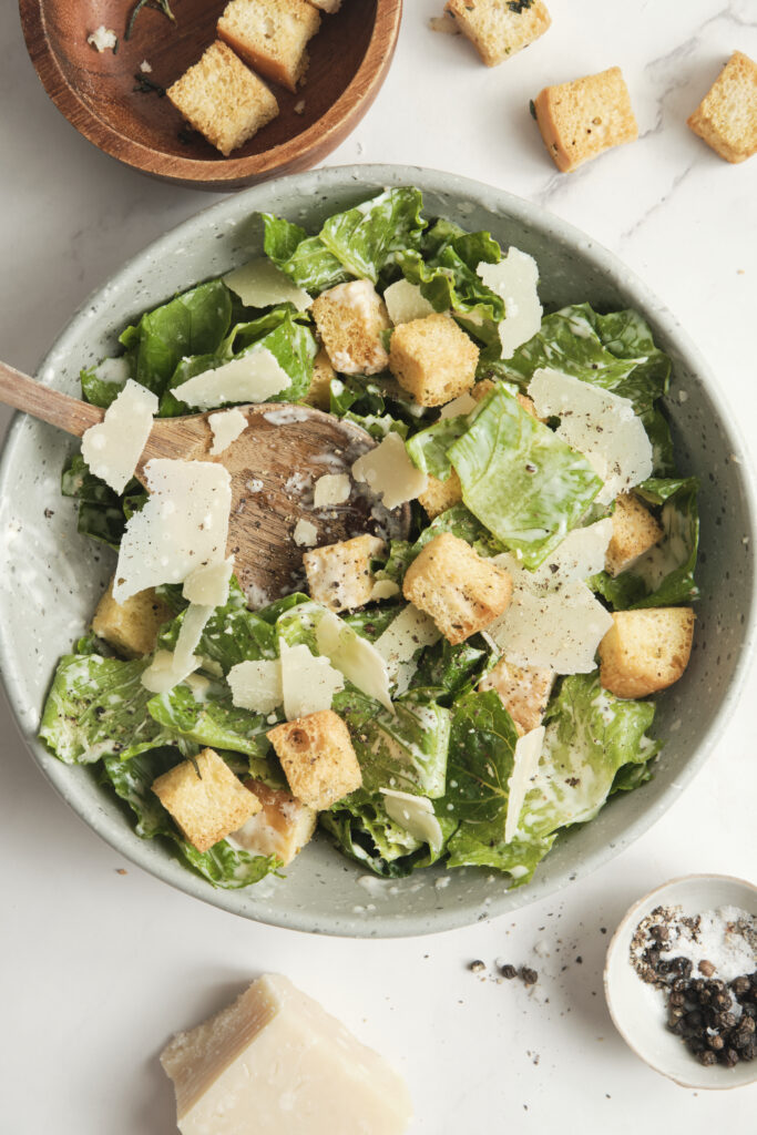 Classic Caesar salad with crisp romaine lettuce, creamy dressing, crunchy croutons, and freshly grated Parmesan cheese, served in a light, airy setting.