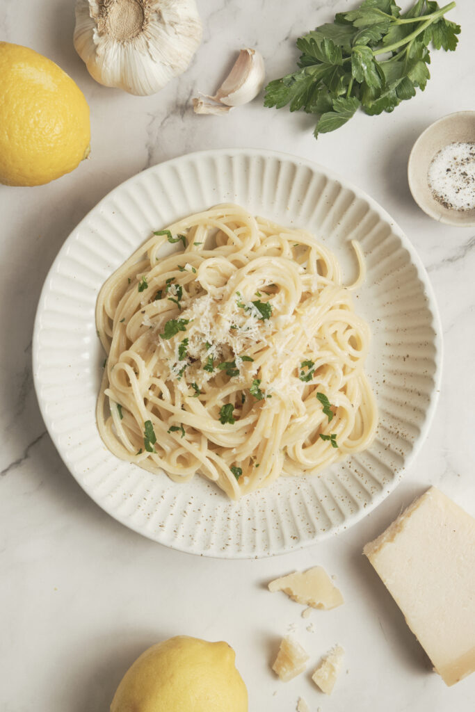 Creamy lemon pasta garnished with fresh parsley and grated Parmesan in a bowl.
