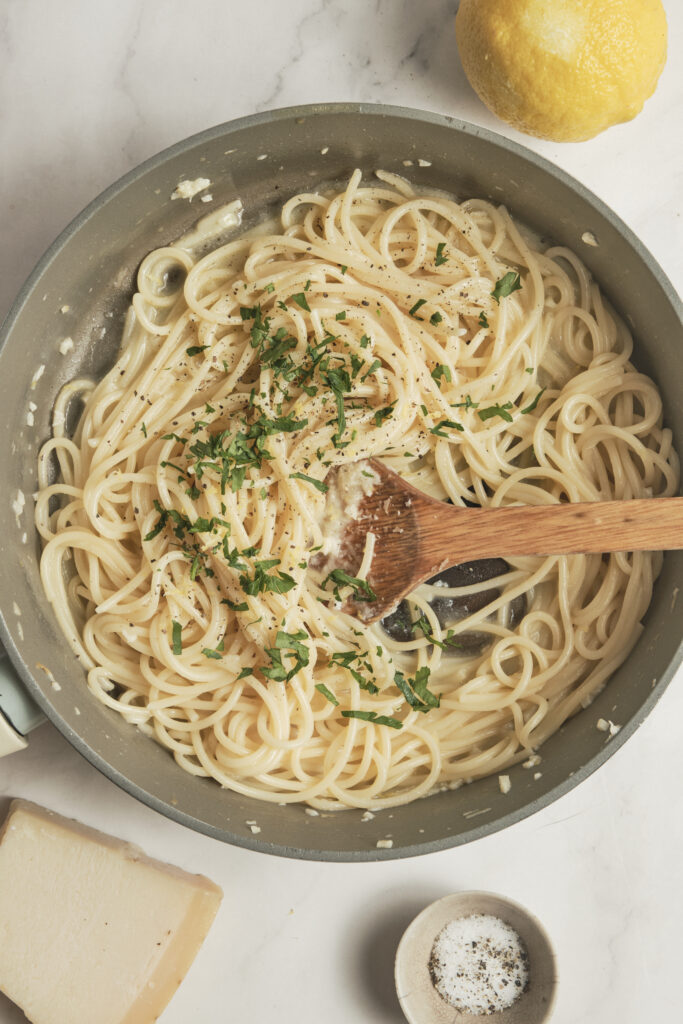 Creamy lemon pasta garnished with fresh parsley and grated Parmesan in a skillet.