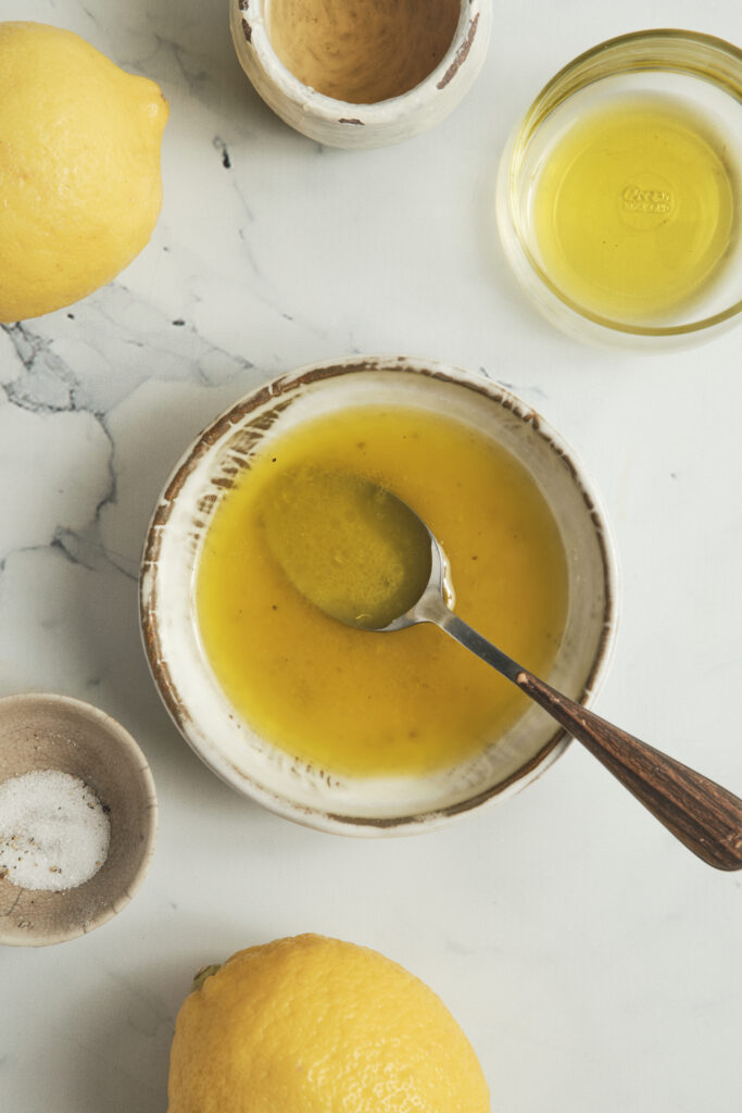 Close-up of a fresh lemon vinaigrette dressing with olive oil, lemon juice, and grated zest.