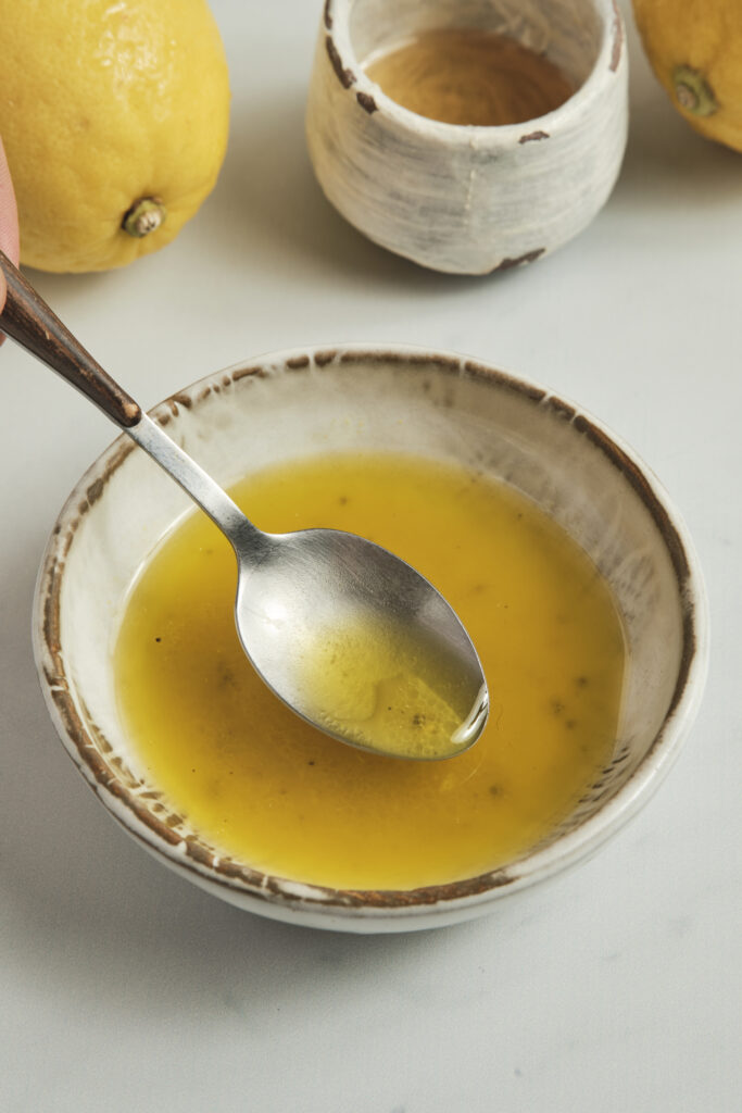 Close-up of a fresh lemon vinaigrette dressing with olive oil, lemon juice, and grated zest.