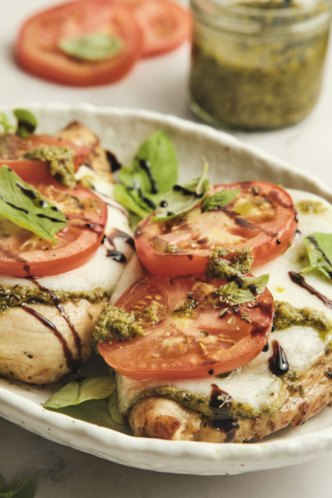 Close-up of caprese chicken with melted cheese and basil