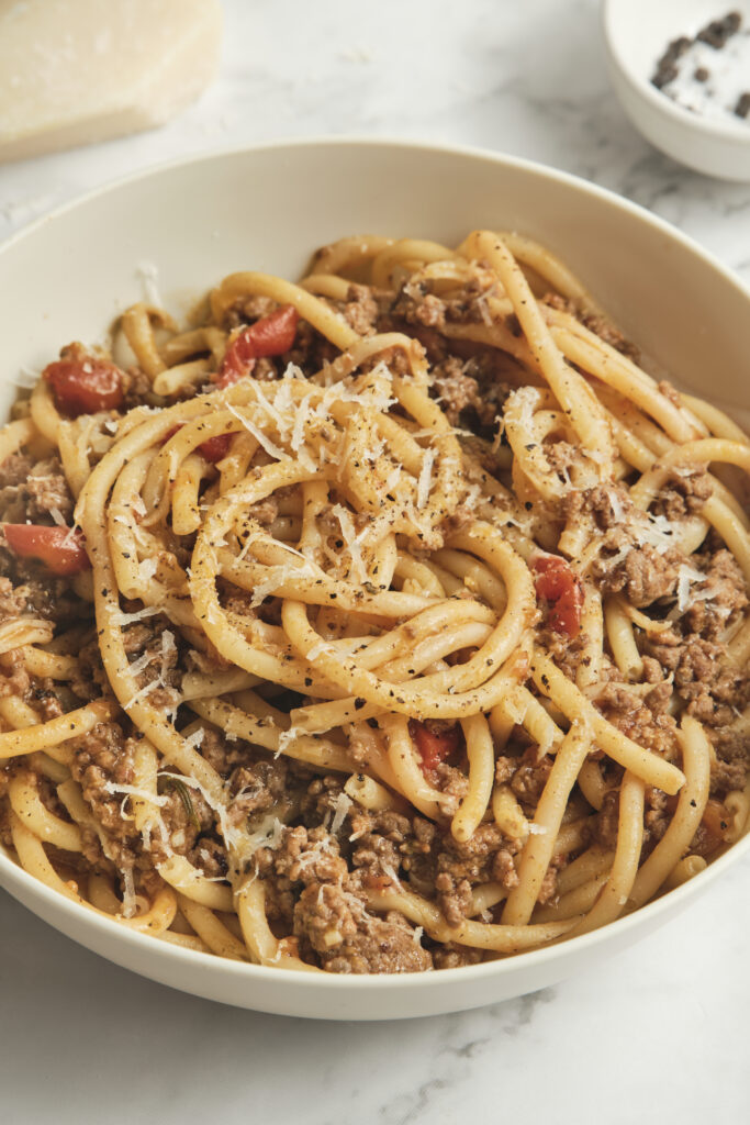 Close-up of sausage ragù pasta tossed in a rich tomato sauce, finished with fresh herbs and grated cheese—an inviting choice for sausage pasta recipes, comforting pasta dinners, and quick dinner ideas.