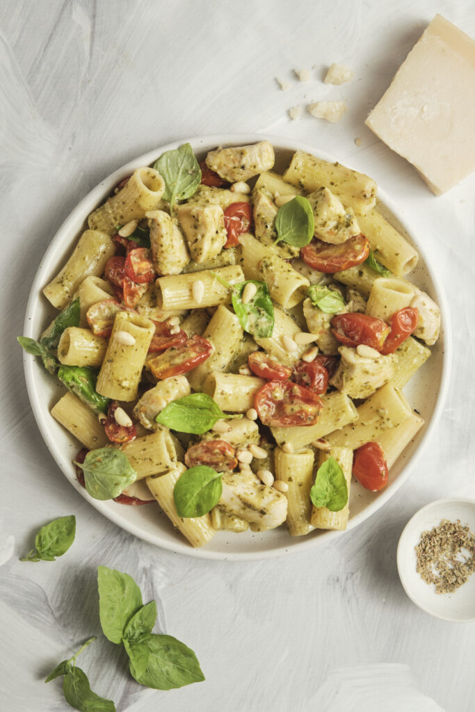 Close-up of creamy pesto pasta with tender chicken pieces
