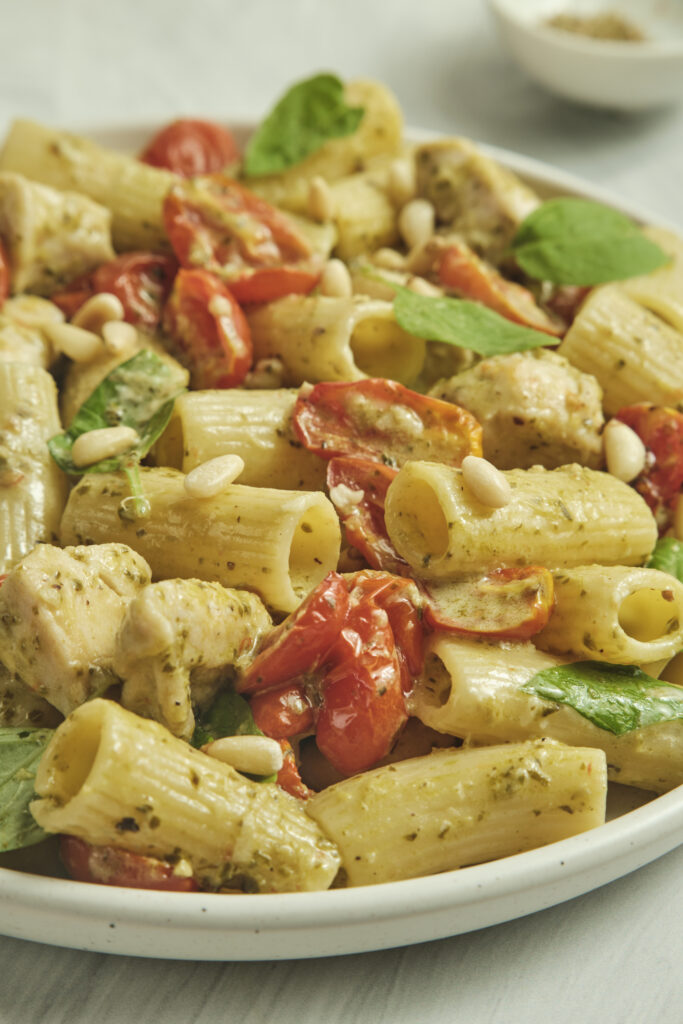 Close-up of creamy pesto pasta with tender chicken pieces