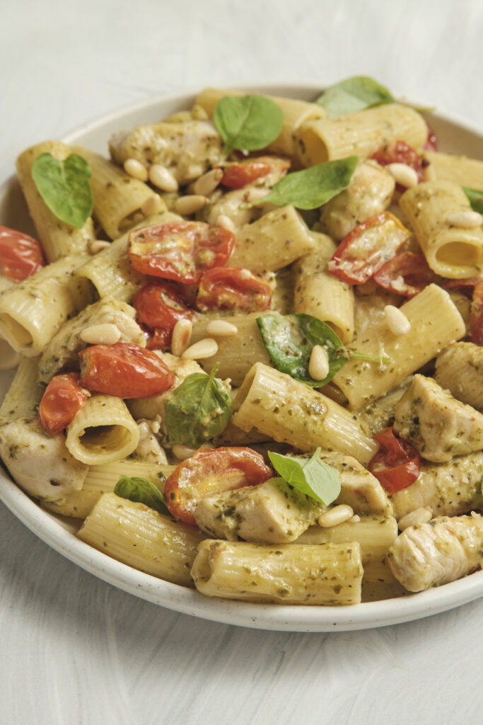 Close-up of creamy pesto pasta with tender chicken pieces