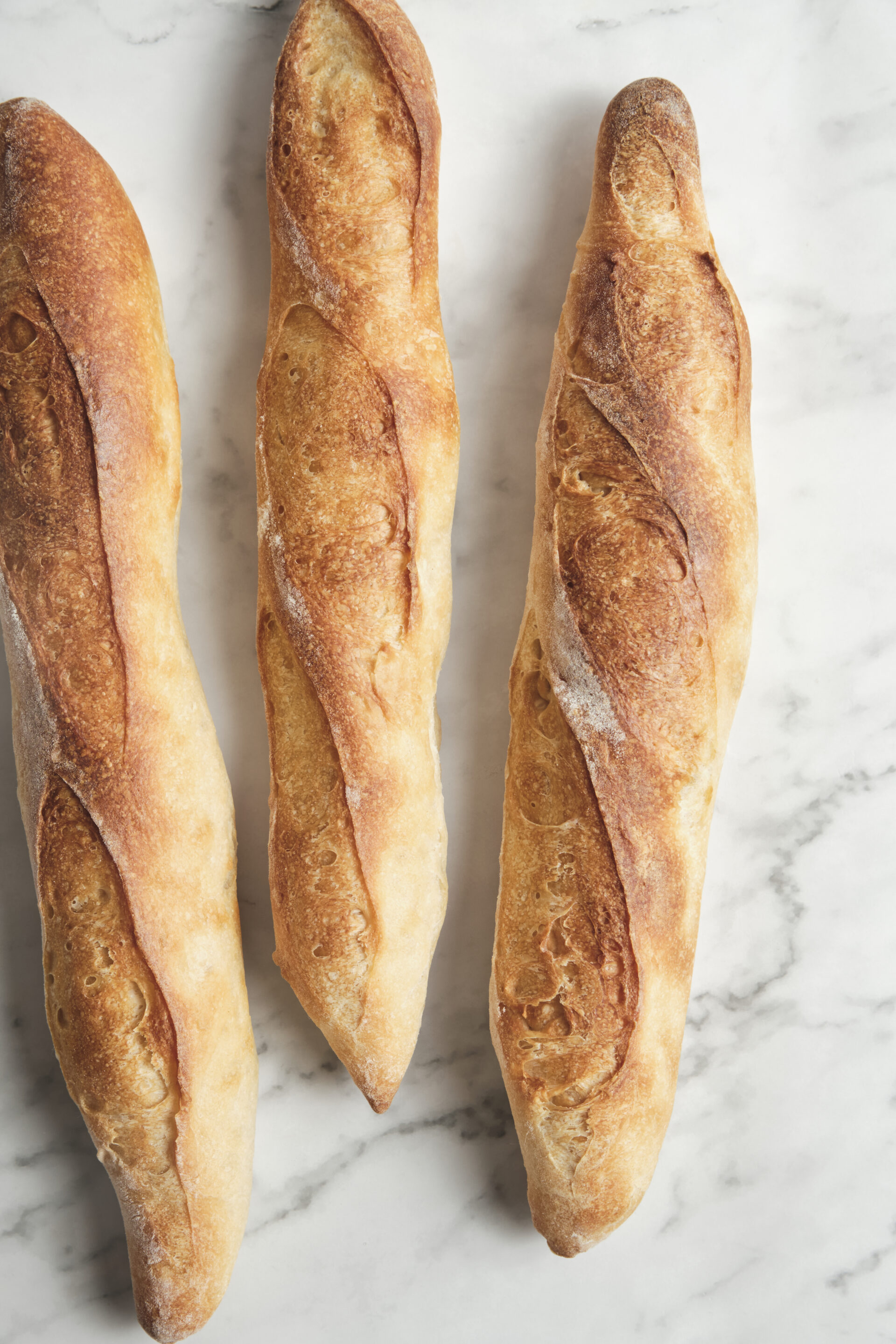 Freshly baked baguette with a golden, crisp crust and airy interior—classic French baguette bread straight from the oven.