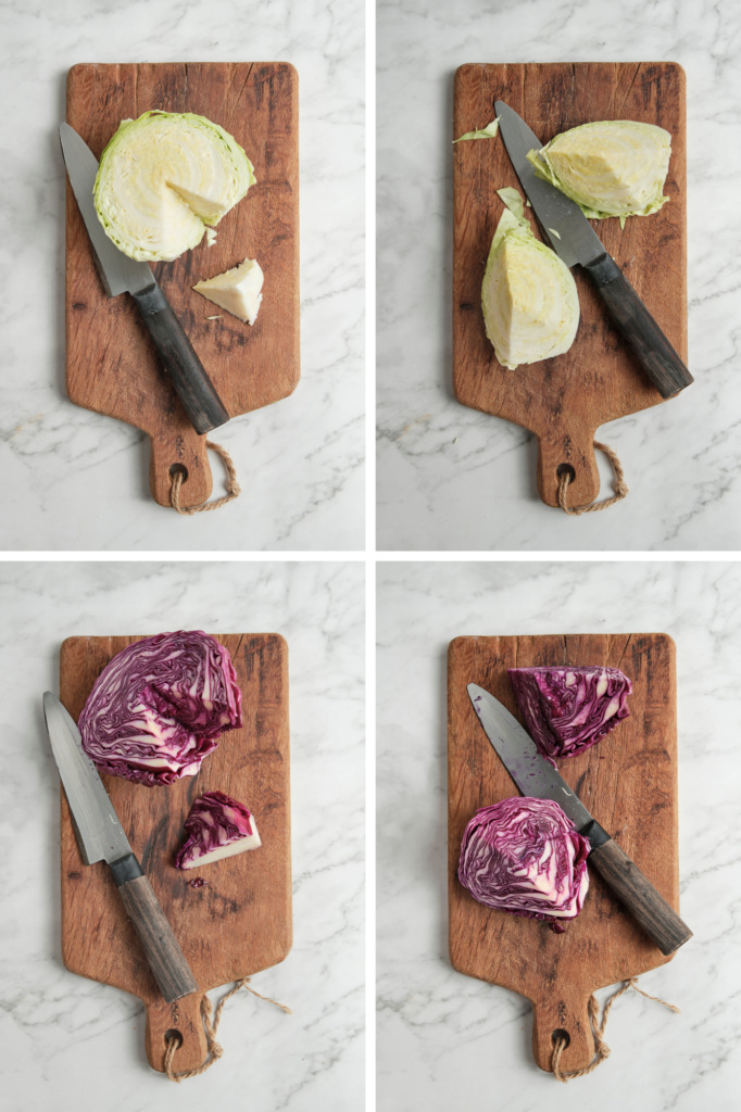 Hands preparing a cabbage by removing the outer leaves, cutting it in half, and trimming out the core, alongside peeled carrots and cleaned vegetables ready for further preparation.