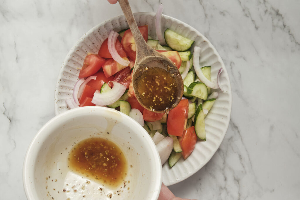 red wine dressing drizzled over the tomato cucumber salad