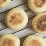 Freshly baked homemade muffins cooling on a wire rack, featuring golden muffin tops and a soft, fluffy texture perfect for breakfast or brunch.