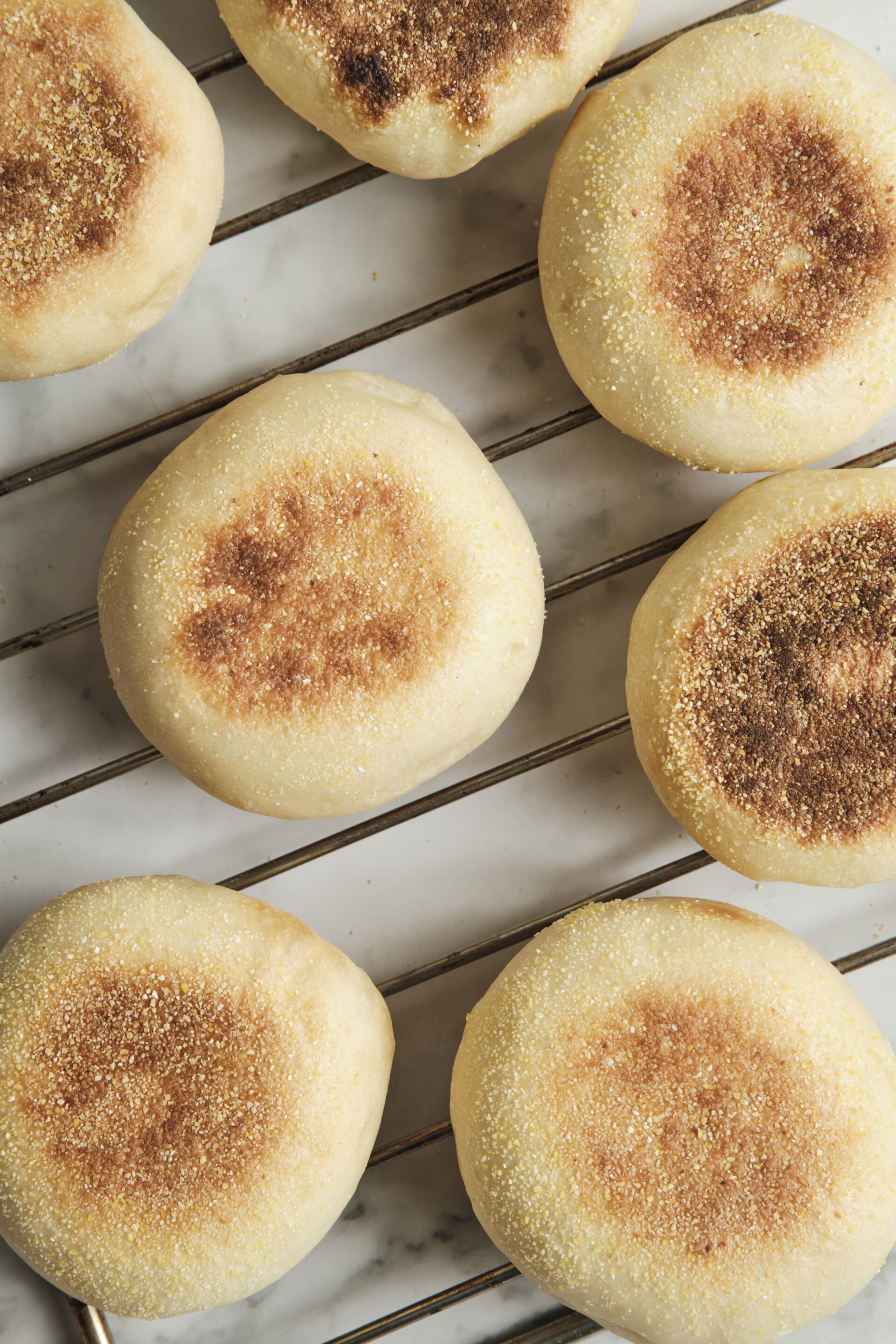 Freshly baked homemade muffins cooling on a wire rack, featuring golden muffin tops and a soft, fluffy texture perfect for breakfast or brunch.