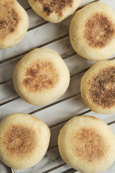 Freshly baked homemade muffins cooling on a wire rack, featuring golden muffin tops and a soft, fluffy texture perfect for breakfast or brunch.