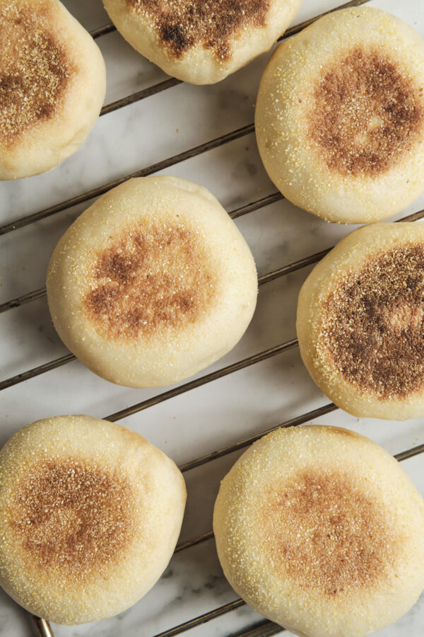 Freshly baked homemade muffins cooling on a wire rack, featuring golden muffin tops and a soft, fluffy texture perfect for breakfast or brunch.