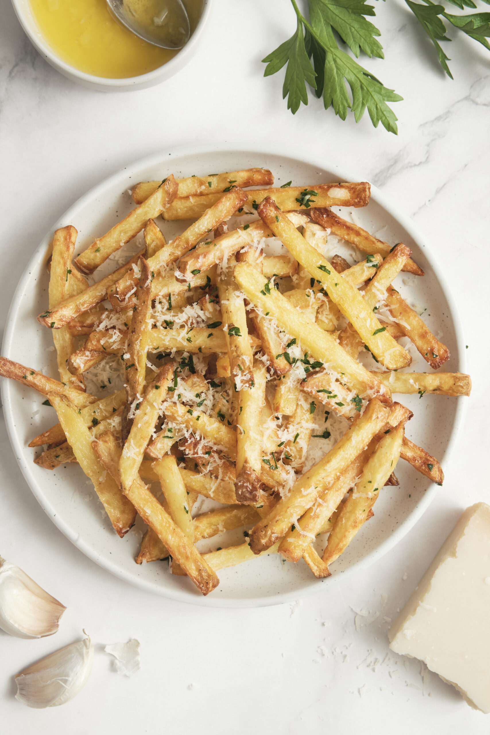 Crispy garlic parmesan french fries made in the air fryer, topped with fresh parsley and parmesan cheese, served as an easy side dish or dinner recipe.