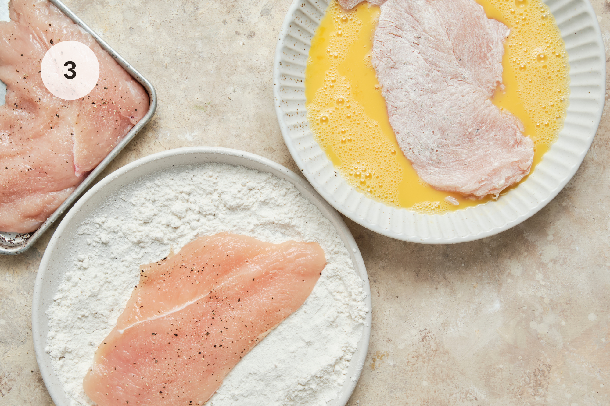Chicken cutlets being coated in flour and dipped into whisked eggs in shallow bowls, preparing the crispy coating for homemade Chicken Francese.