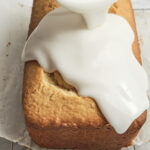 Easy homemade lemon glaze being poured over a freshly baked cake, creating a glossy citrus icing that drips down the sides.