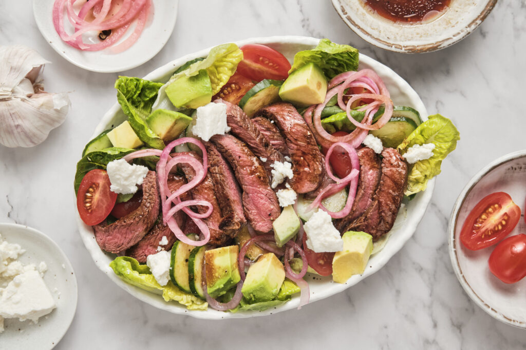 salad and steak assembled on a plate