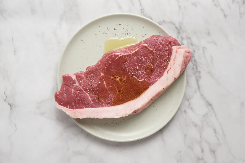steak seasonend with salt pepper on a plate
