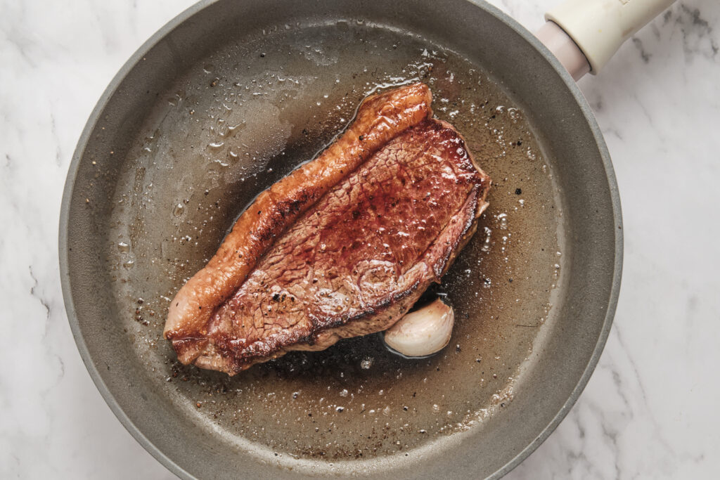 steak is seared in a skillet