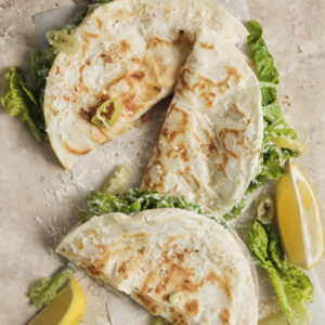 Crispy smashed chicken tacos topped with a fresh, creamy Caesar salad, and shaved parmesan,