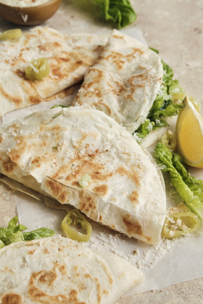 Close-up of a crispy smashed chicken taco tortilla side up on a surface, showing its nicely browned, toasted edges.