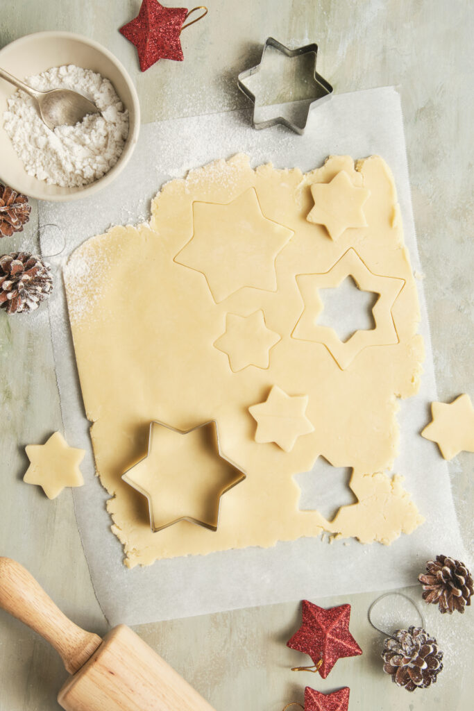 Christmas Cookie Dough on a surface, with star cookie cutters